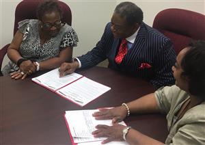 The director with two consumers working on paperwork. The director with two consumers working on paperwork.